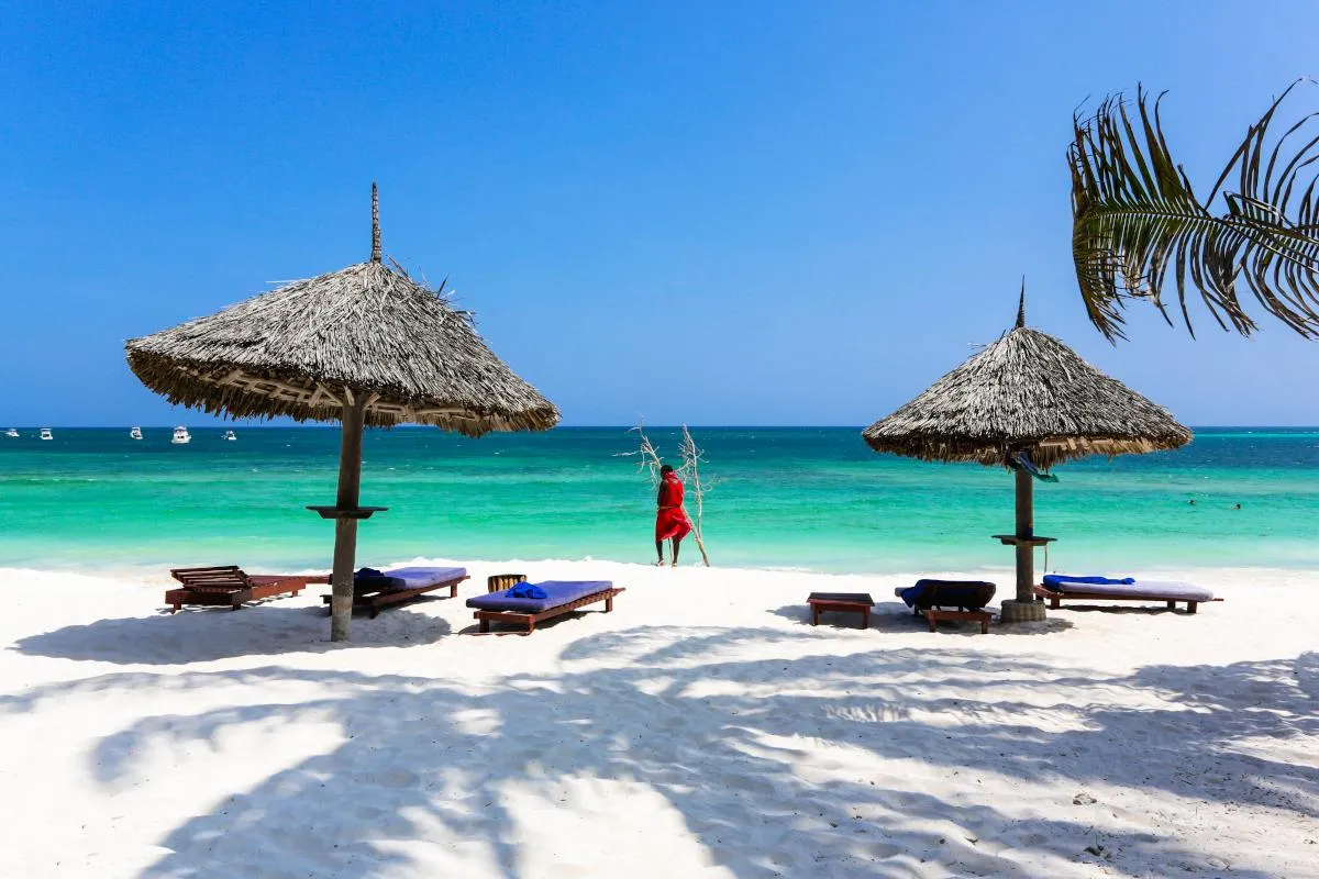 Thatched umbrellas on a white beach by the turquoise sea